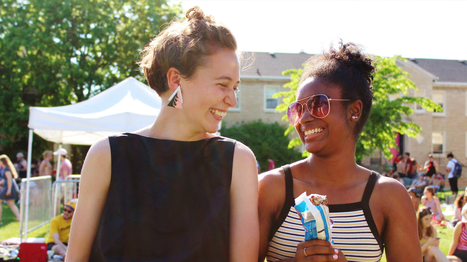 Two lawrence students smiling at each other outside